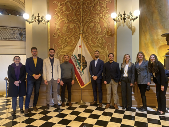 Group of people posing for photo, California Republic flag is in center of group