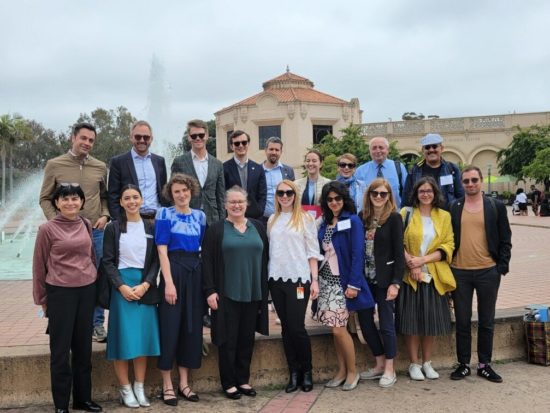 A group of 18 professionals, representing IVLP participants and representatives from SANDAG are pictured outside in front of a fountain and science center.