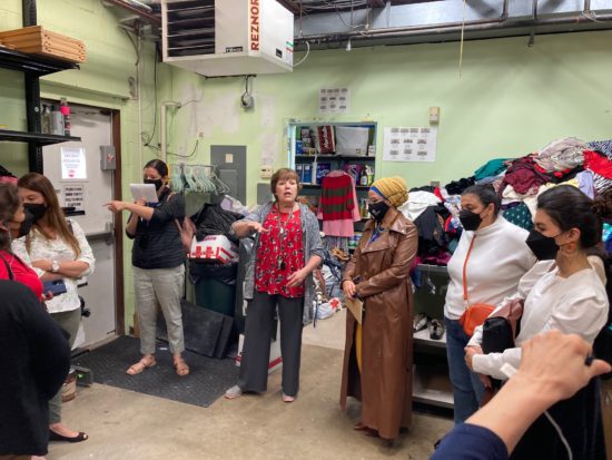 A women explaining information to a group of women while in the power center.