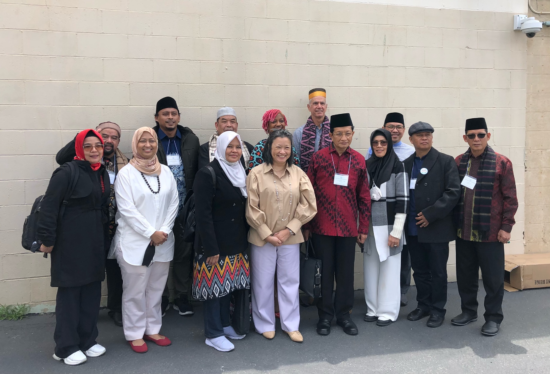 Visitors from Indonesia stand and smile in a group photo.