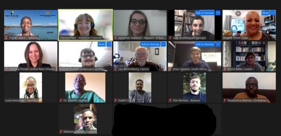 People smiling on a screenshot of a Zoom meeting.