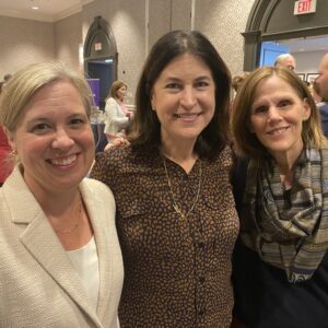 Three women pose for photo.