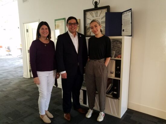 Two women and one man pose for photo.