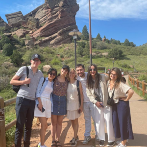 Group of people pose for picture in front of Colorado landscape.